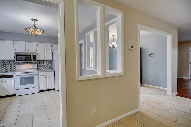 kitchen with white cabinetry, stainless steel microwave, tasteful backsplash, and white electric stove