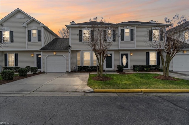 colonial home with an attached garage, driveway, and a front yard