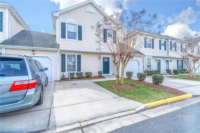 view of front of home featuring an attached garage, driveway, and roof with shingles