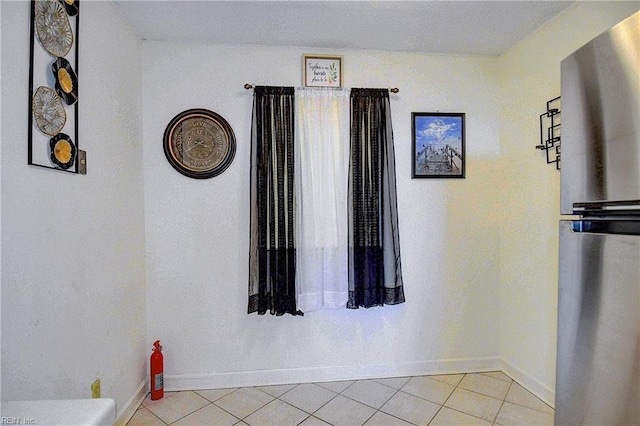 hallway with baseboards and light tile patterned flooring