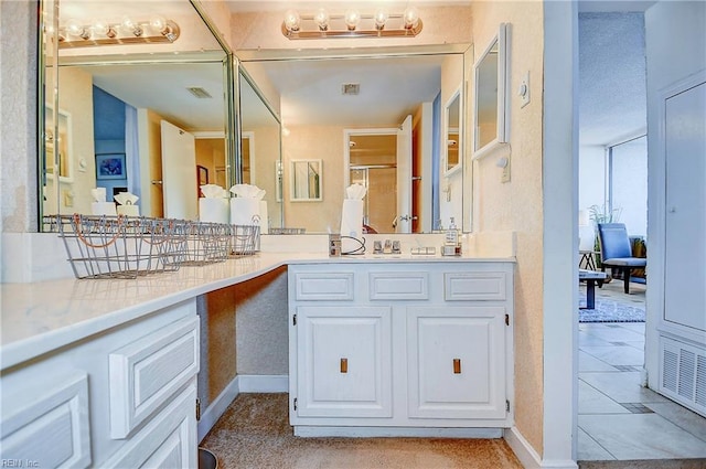 full bathroom with a shower with door, visible vents, and vanity