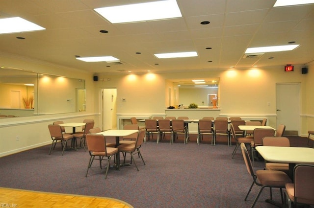 carpeted dining space featuring visible vents, a paneled ceiling, crown molding, and baseboards