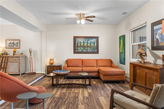 living area with a ceiling fan, wood finished floors, visible vents, and baseboards