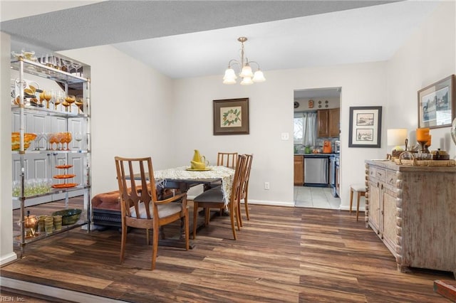 dining room featuring baseboards, an inviting chandelier, and wood finished floors