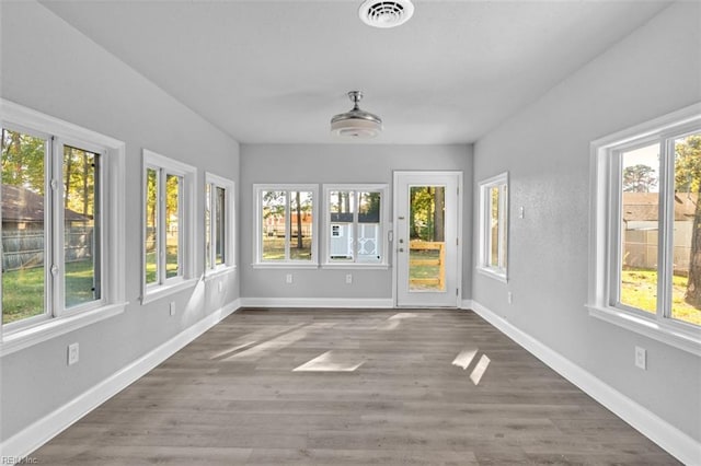 unfurnished sunroom featuring visible vents and a healthy amount of sunlight