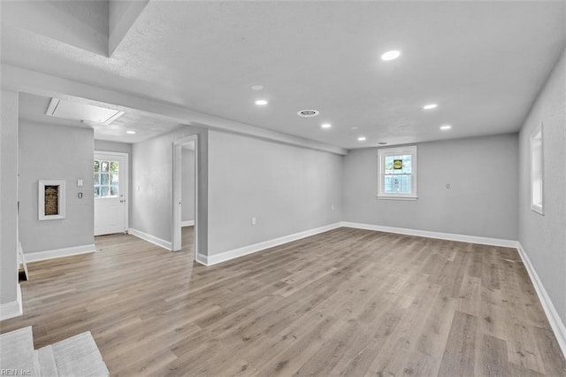 below grade area featuring light wood-style flooring, plenty of natural light, recessed lighting, and baseboards