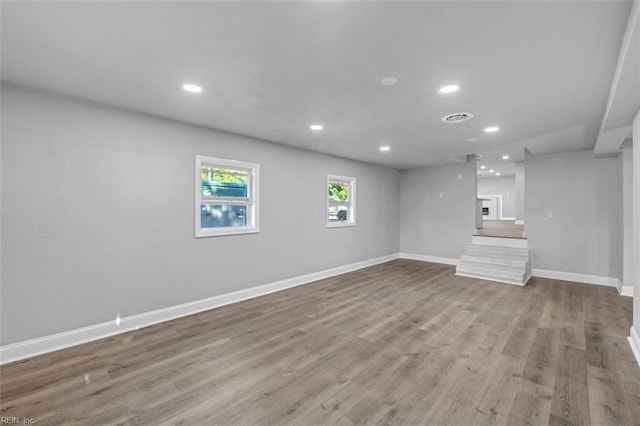 unfurnished living room featuring visible vents, recessed lighting, wood finished floors, and baseboards