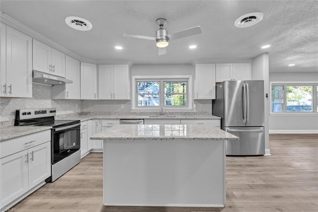 kitchen featuring visible vents, light wood-type flooring, under cabinet range hood, and stainless steel appliances