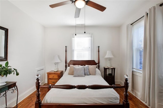 bedroom with visible vents, multiple windows, baseboards, and wood finished floors