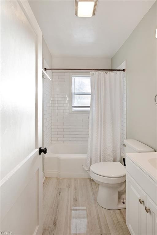 bathroom featuring vanity, toilet, wood finished floors, and shower / tub combo