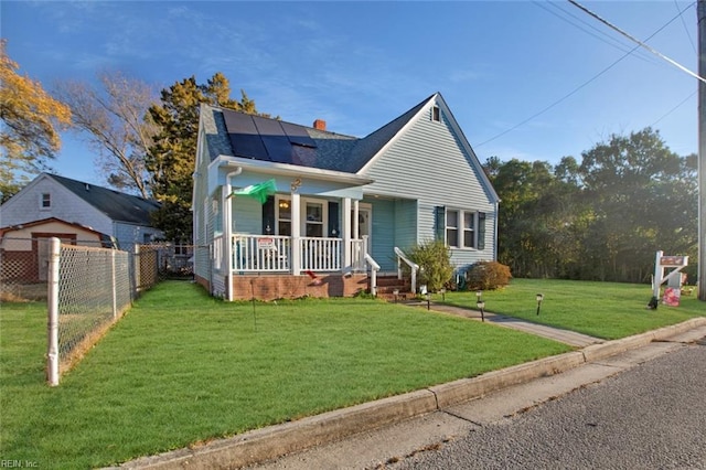 bungalow-style house featuring solar panels, fence, a porch, a front yard, and a chimney