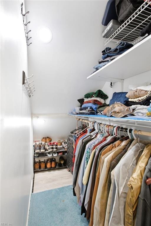 walk in closet with wood finished floors