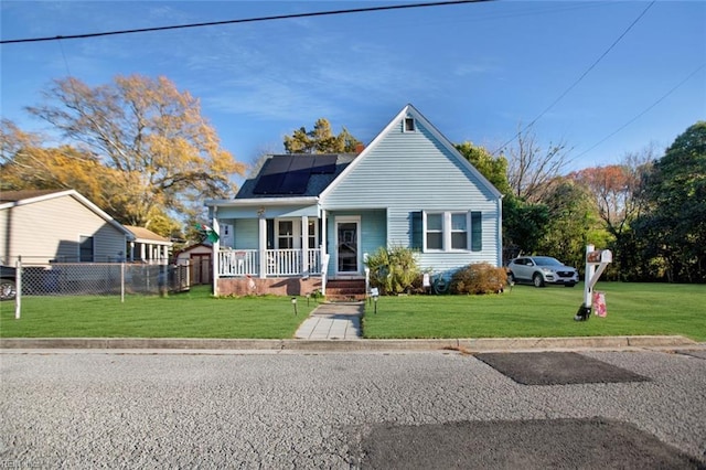 bungalow with solar panels, a front yard, fence, and covered porch