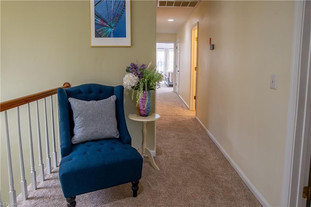 corridor with visible vents, baseboards, and carpet