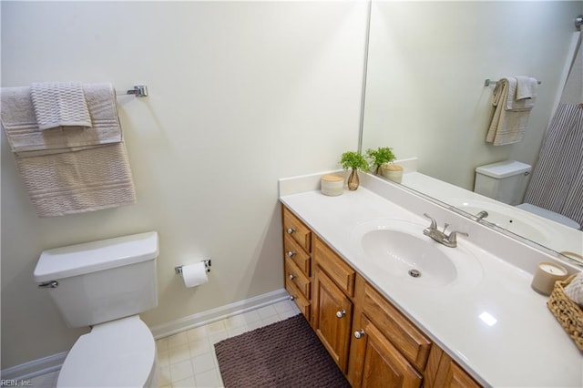 bathroom featuring toilet, vanity, and baseboards