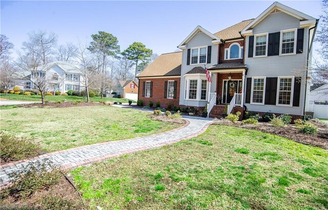 traditional-style house with brick siding and a front yard