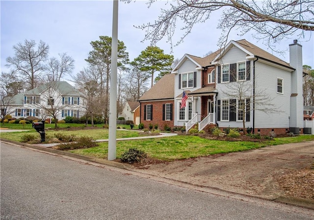 traditional-style home featuring crawl space, a front lawn, a residential view, and a chimney