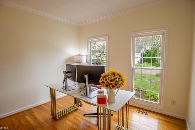 home office with visible vents, plenty of natural light, wood finished floors, and ornamental molding