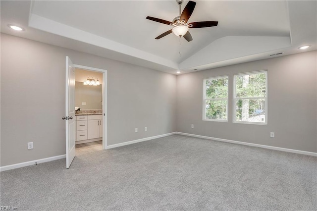 unfurnished bedroom featuring baseboards, lofted ceiling, and light colored carpet