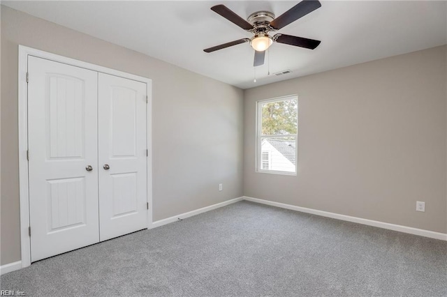 unfurnished bedroom featuring visible vents, baseboards, carpet floors, a closet, and a ceiling fan