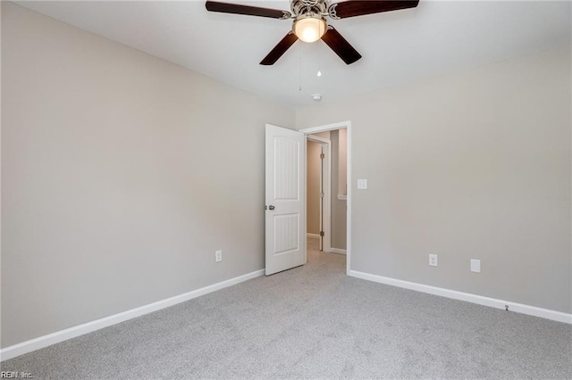 empty room featuring ceiling fan, baseboards, and light carpet