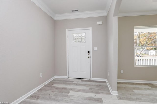 foyer featuring visible vents, light wood finished floors, and ornamental molding