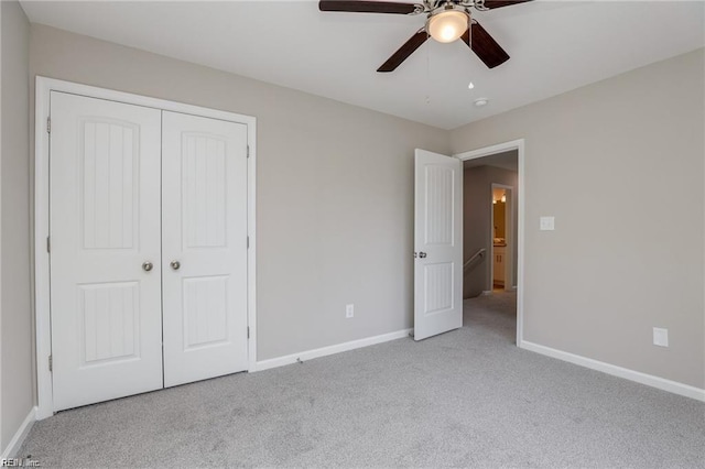 unfurnished bedroom featuring carpet, baseboards, a closet, and ceiling fan