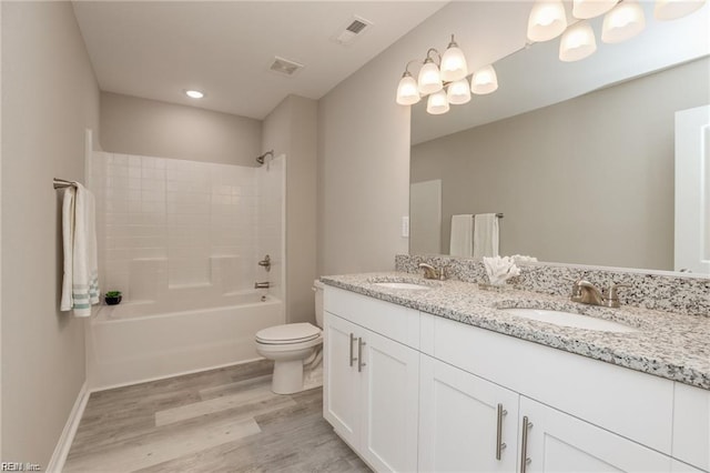 full bath with toilet, wood finished floors, visible vents, and a sink