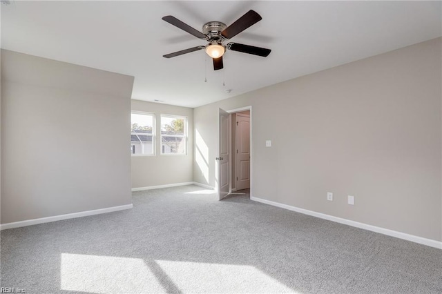 empty room with a ceiling fan, baseboards, and carpet floors