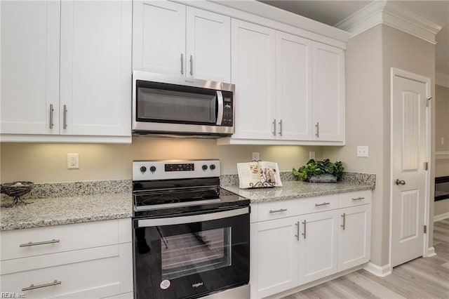 kitchen with stainless steel appliances, light stone countertops, light wood-style floors, and white cabinetry