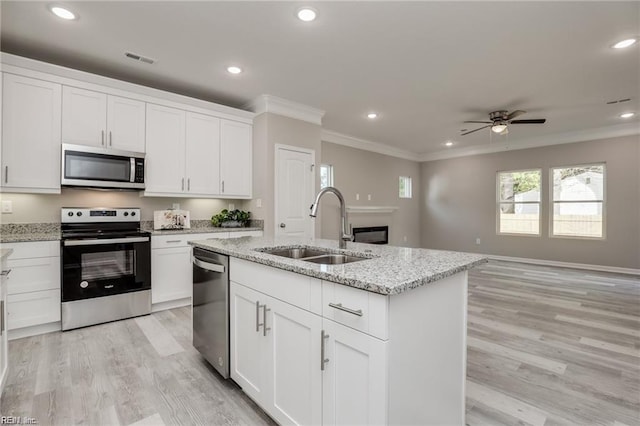 kitchen with visible vents, a sink, recessed lighting, stainless steel appliances, and crown molding