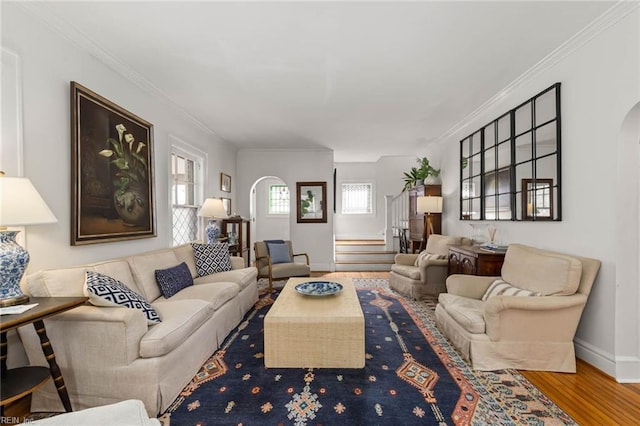 living room with baseboards, wood finished floors, arched walkways, and ornamental molding