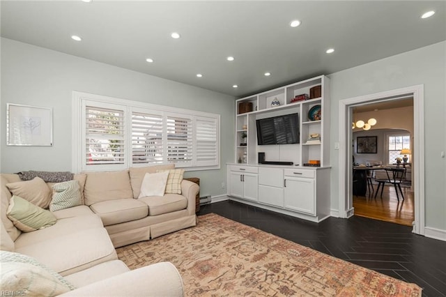 living area with recessed lighting, baseboards, arched walkways, and dark wood finished floors