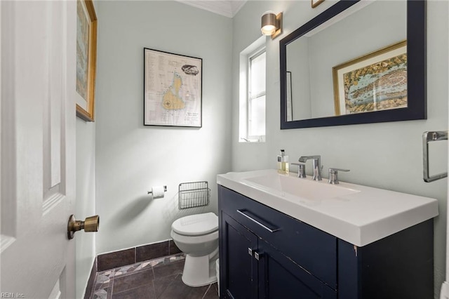 half bath with baseboards, toilet, vanity, and tile patterned flooring