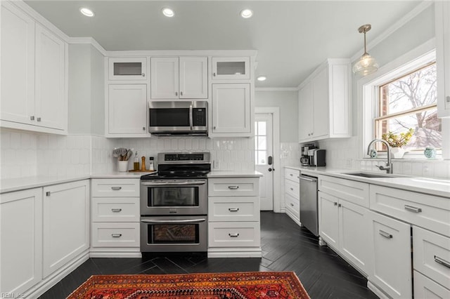 kitchen featuring a healthy amount of sunlight, appliances with stainless steel finishes, white cabinetry, and a sink