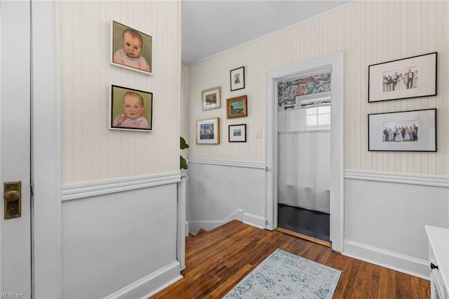 hallway featuring dark wood finished floors and baseboards