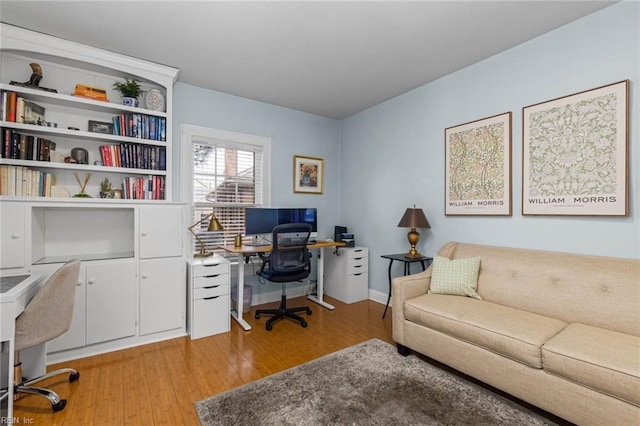 office area featuring light wood-type flooring and baseboards