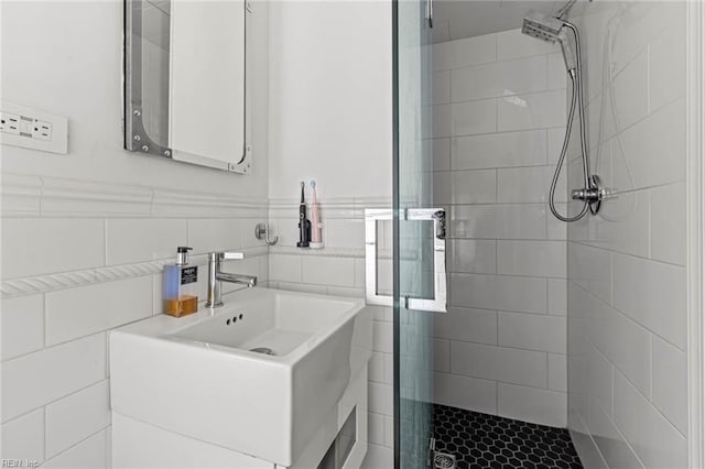 full bath with vanity, tile walls, a stall shower, and wainscoting