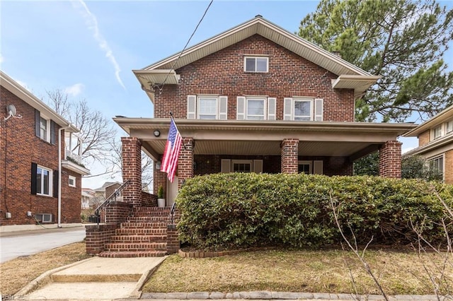 traditional-style house featuring a porch and brick siding