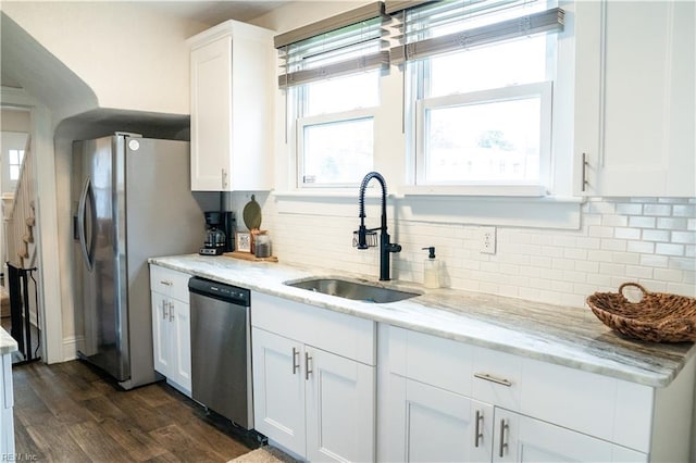 kitchen featuring a sink, decorative backsplash, white cabinets, stainless steel appliances, and dark wood-style flooring