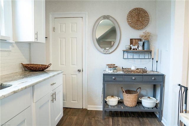 interior space featuring baseboards and dark wood-style flooring