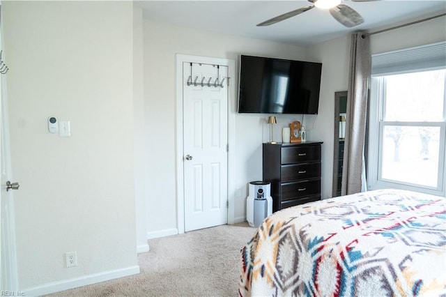 carpeted bedroom with a ceiling fan and baseboards