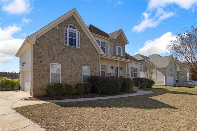 view of front of property with a garage, stone siding, a front yard, and driveway