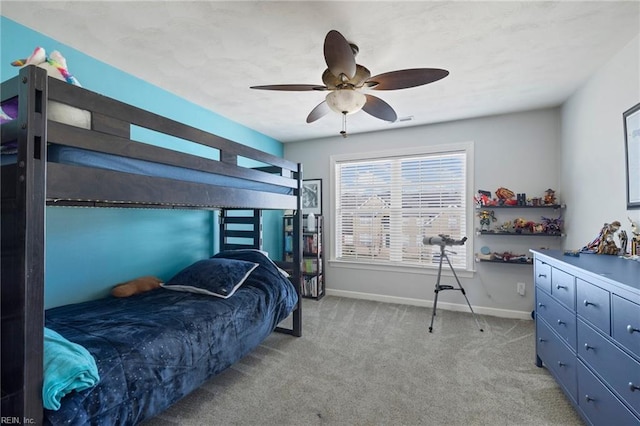 bedroom featuring light colored carpet, baseboards, and ceiling fan