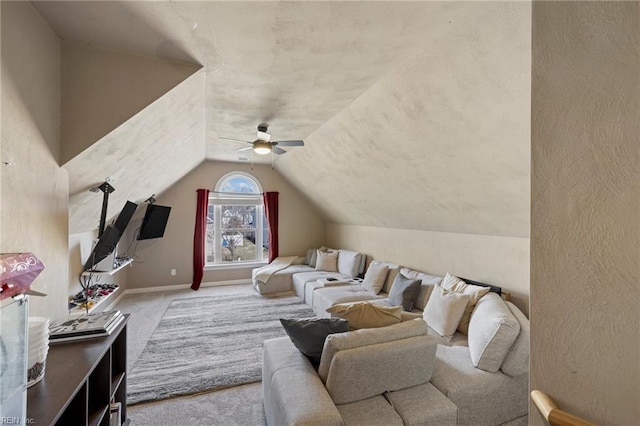 living room with ceiling fan, baseboards, lofted ceiling, and carpet floors