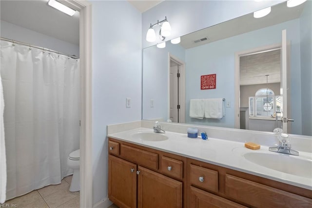 bathroom featuring tile patterned floors, visible vents, double vanity, and a sink