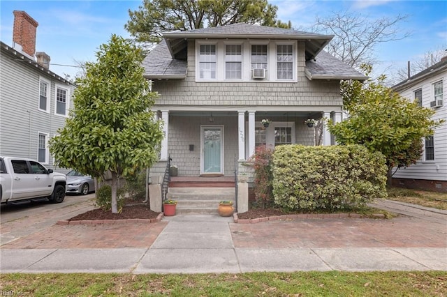 view of front facade featuring covered porch and roof with shingles