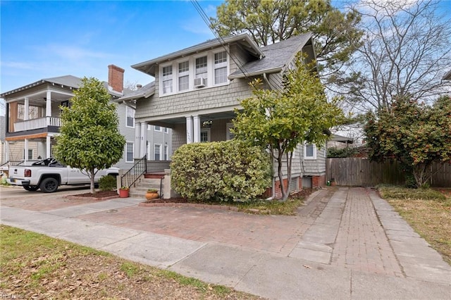 view of front of home featuring decorative driveway and fence