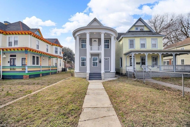 victorian-style house with a front lawn, central AC unit, and covered porch