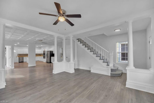 interior space featuring stairway, dark wood-style floors, baseboards, and ornate columns